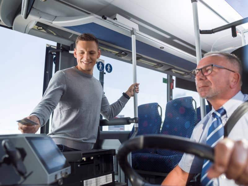 Bargeldloses Bezahlen in den Regionalbussen ist nun möglich. Mann bezahlt mit Kreditkarte beim Einsteigen.